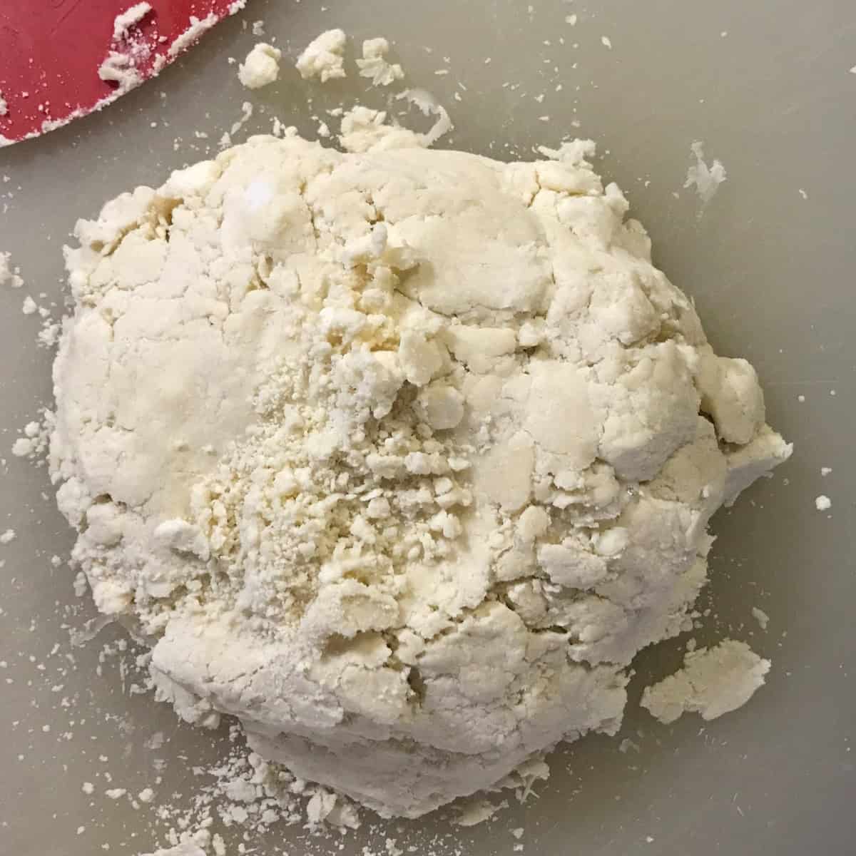 Butter and lard cut into flour to create a flaky pie dough.