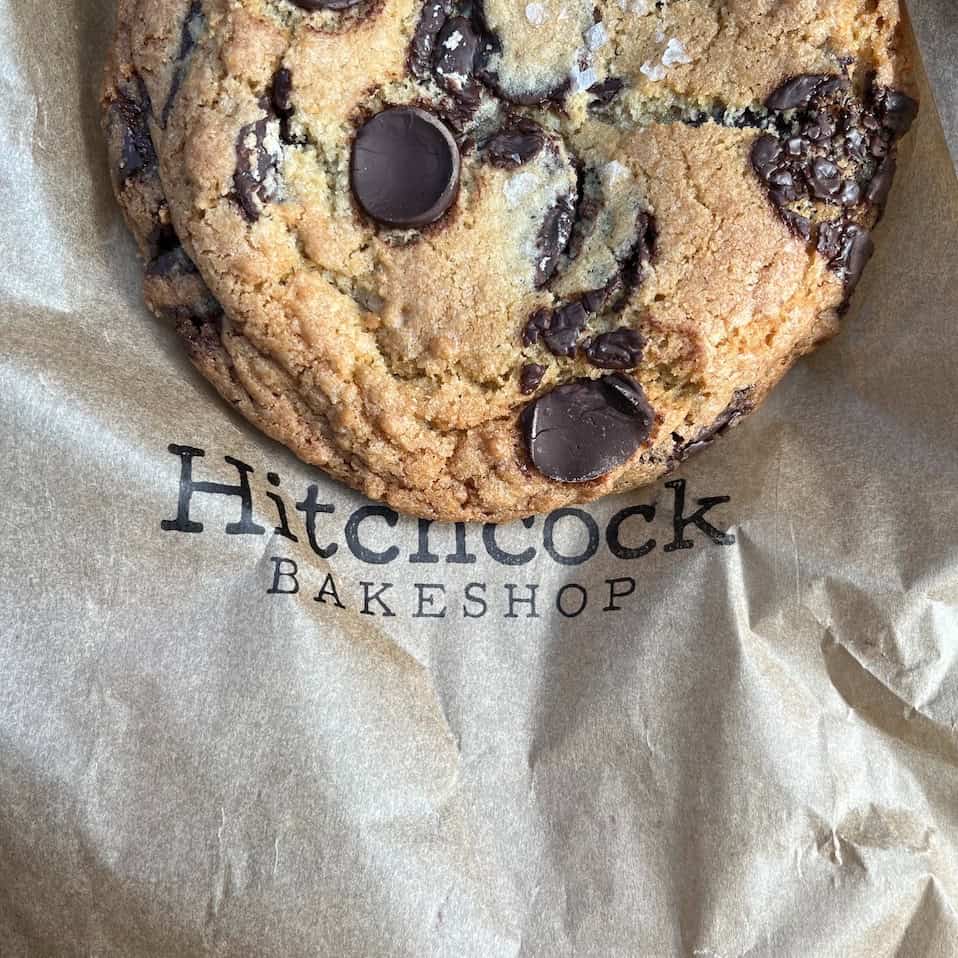 Chocolate chip cookie resting on a bakeshop bag