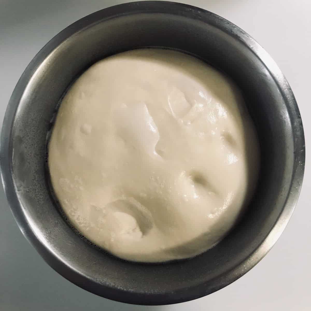 Dough in bowl after proofing with finger indentation