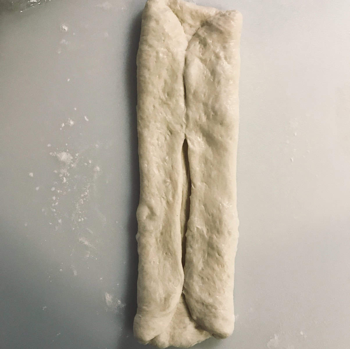 Shokupan milk bread dough with left and right sides folded and meeting in the middle
