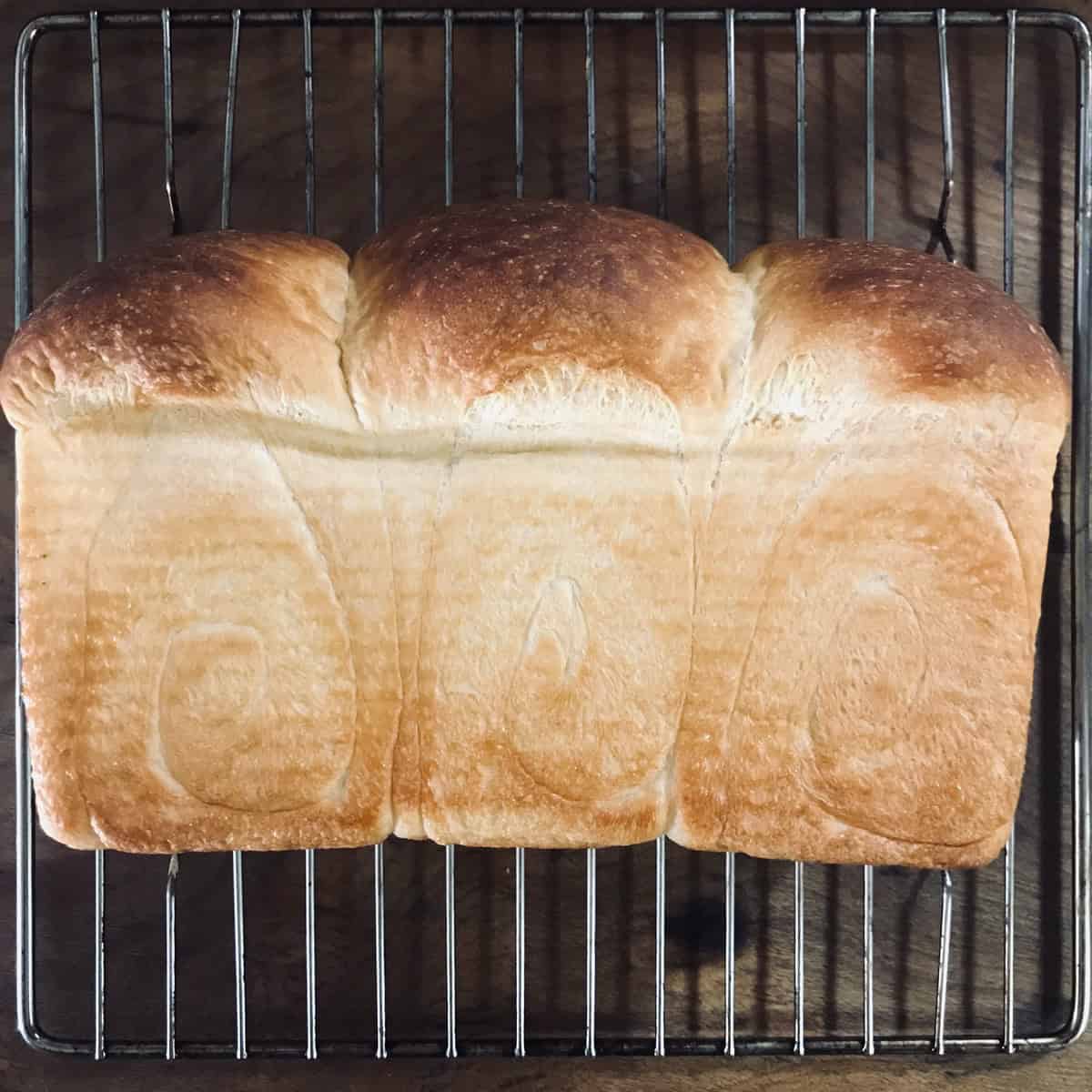 Baked shokupan milk bread removed from pan and on wire rack
