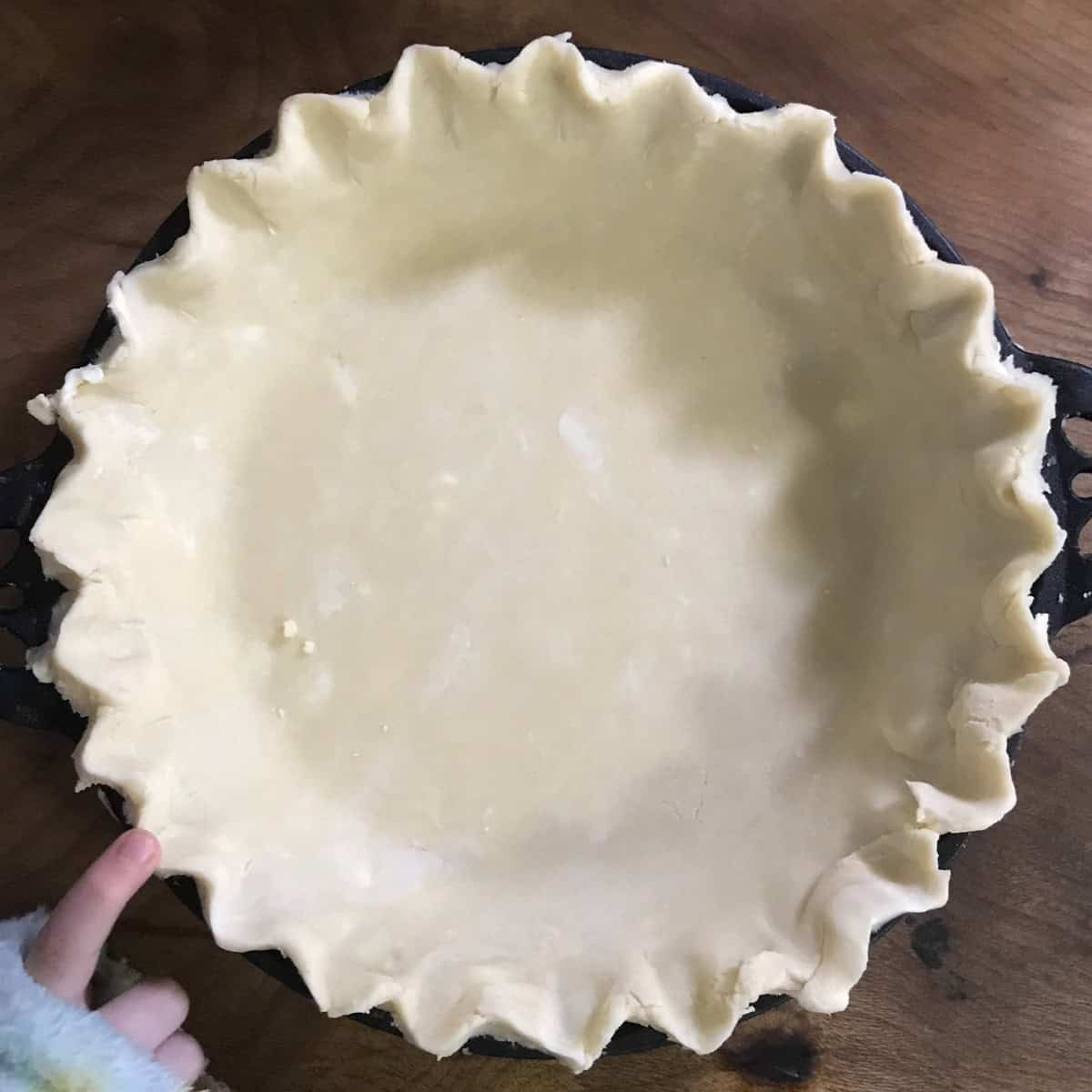 Pie dough formed in pan, with crimping.