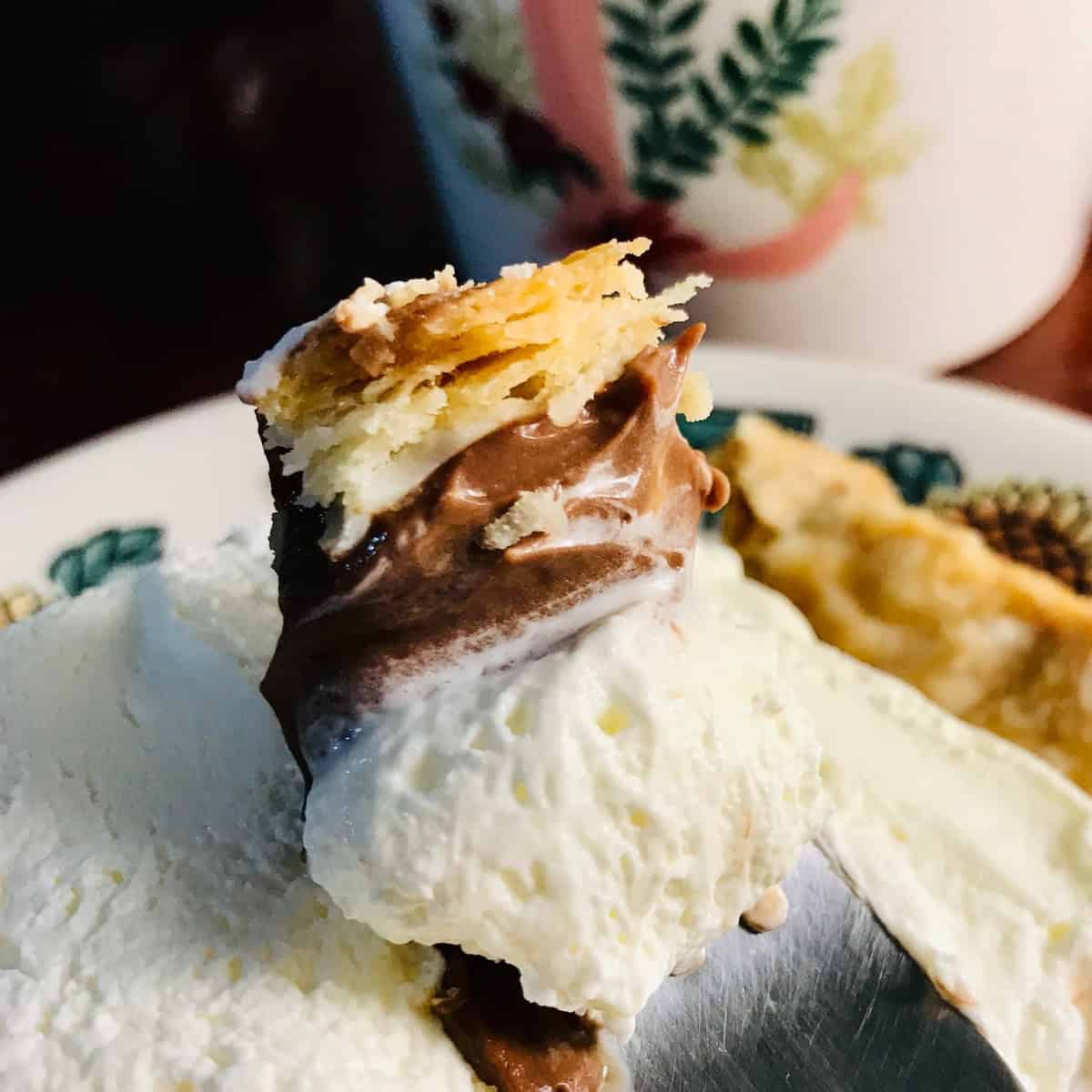 close-up shot of chocolate cream pie with flaky crust layers visible.