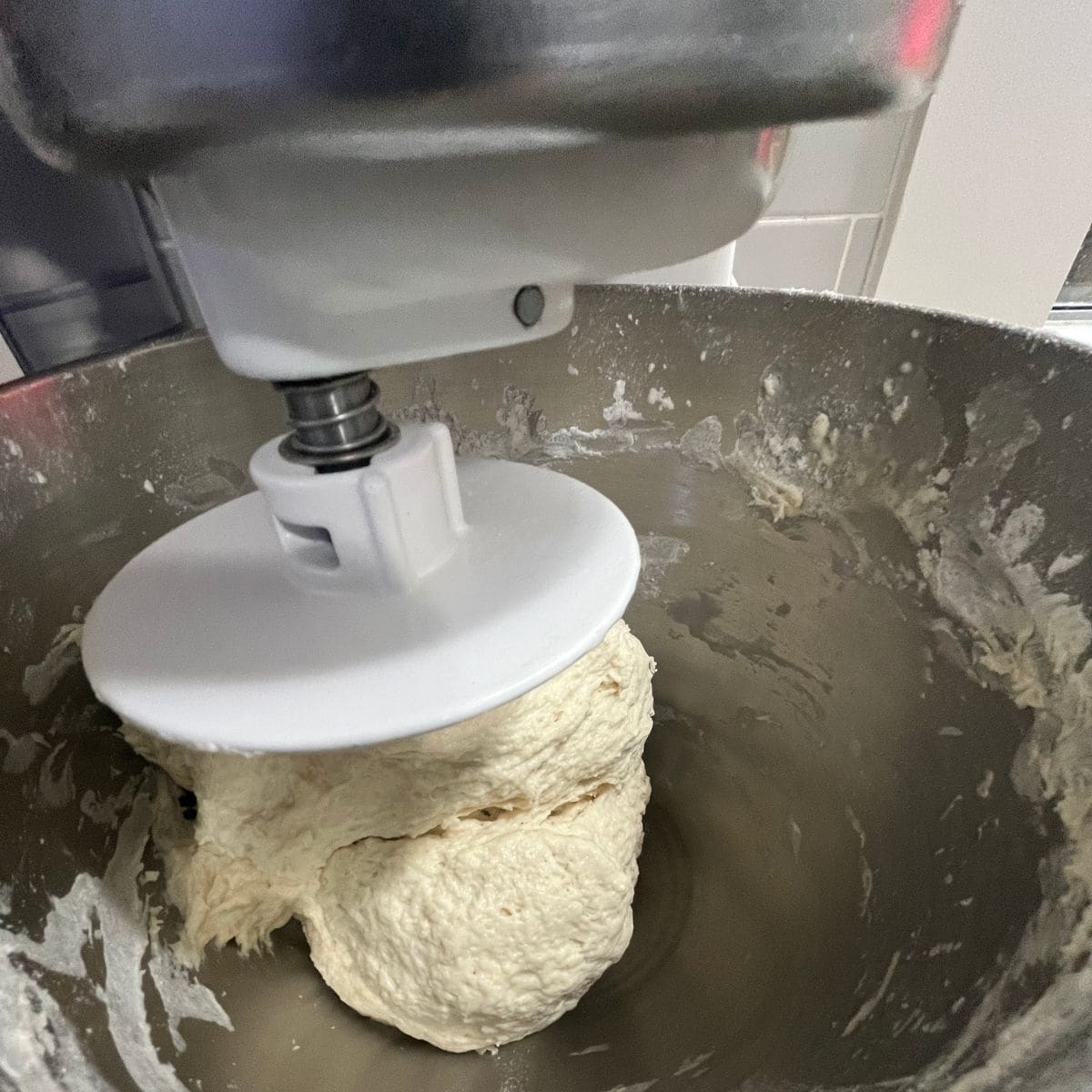 A shaggy dough mixing in a KitchenAid at slow speed.