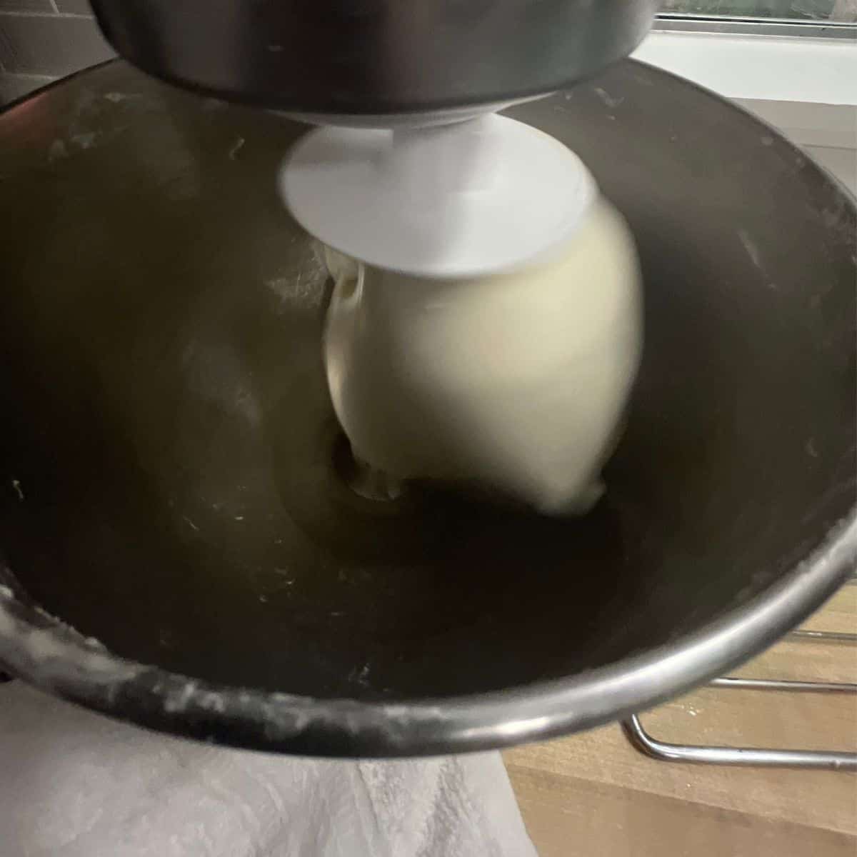 A smoother dough mixing in a KitchenAid at medium-high speed.