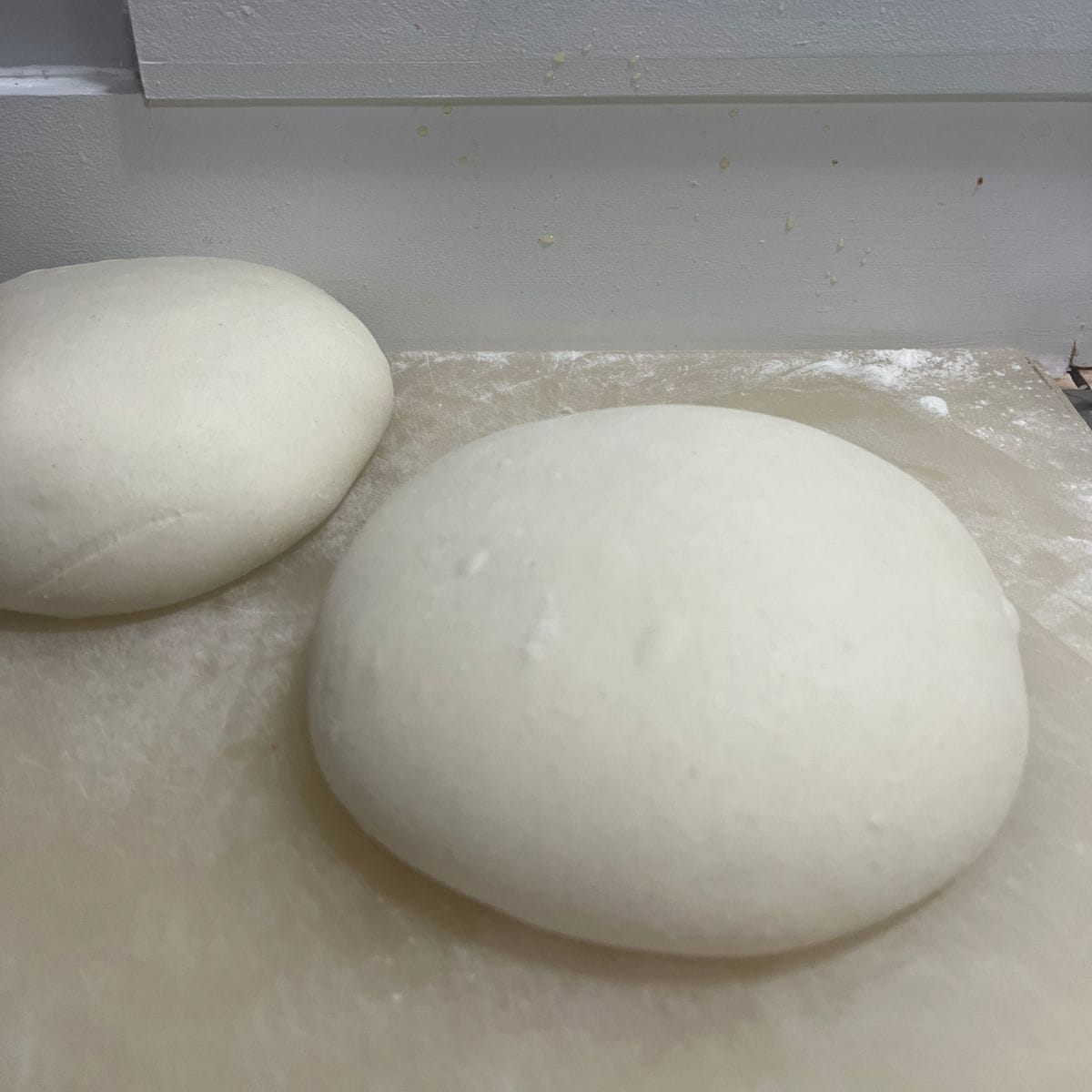 Two focaccia dough, rounded with smooth tops.