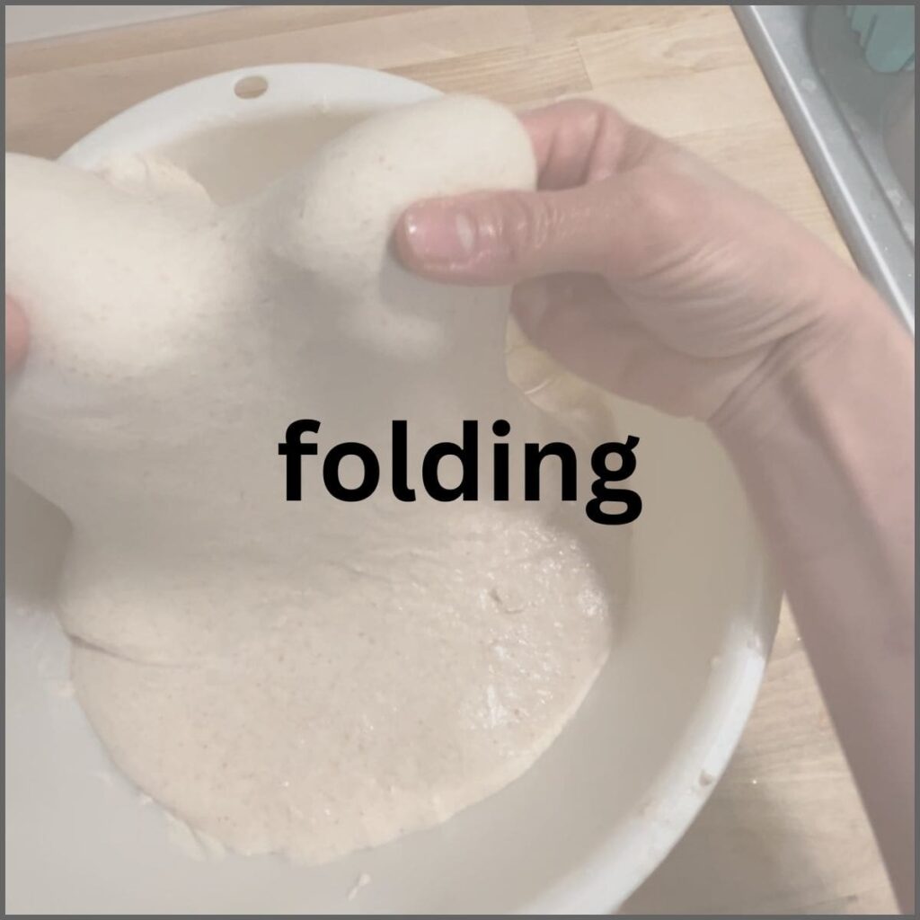 Two hands lifting dough up from the center