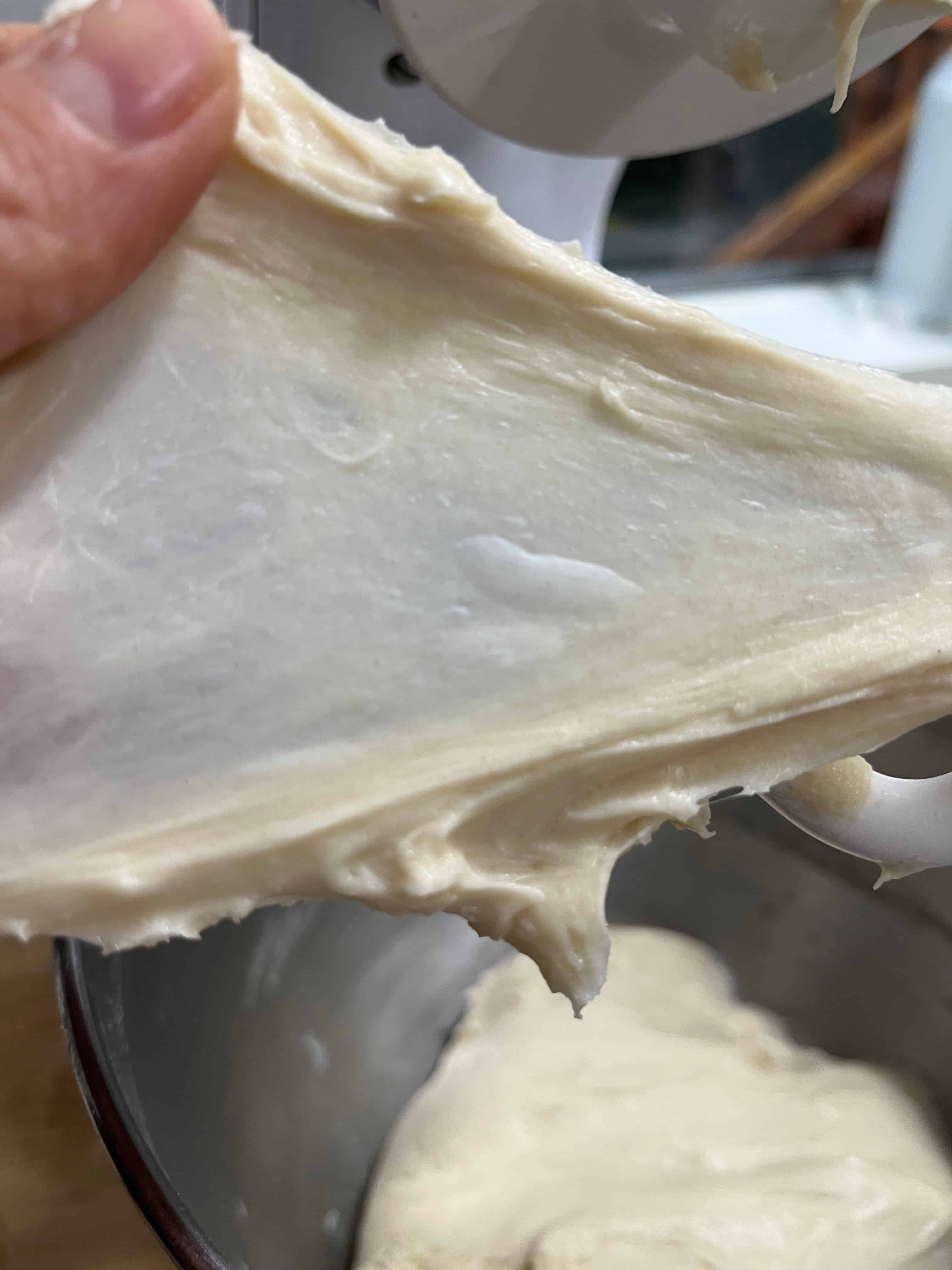 Stretching the dough thin (windowpane test) indicates a well developed dough.