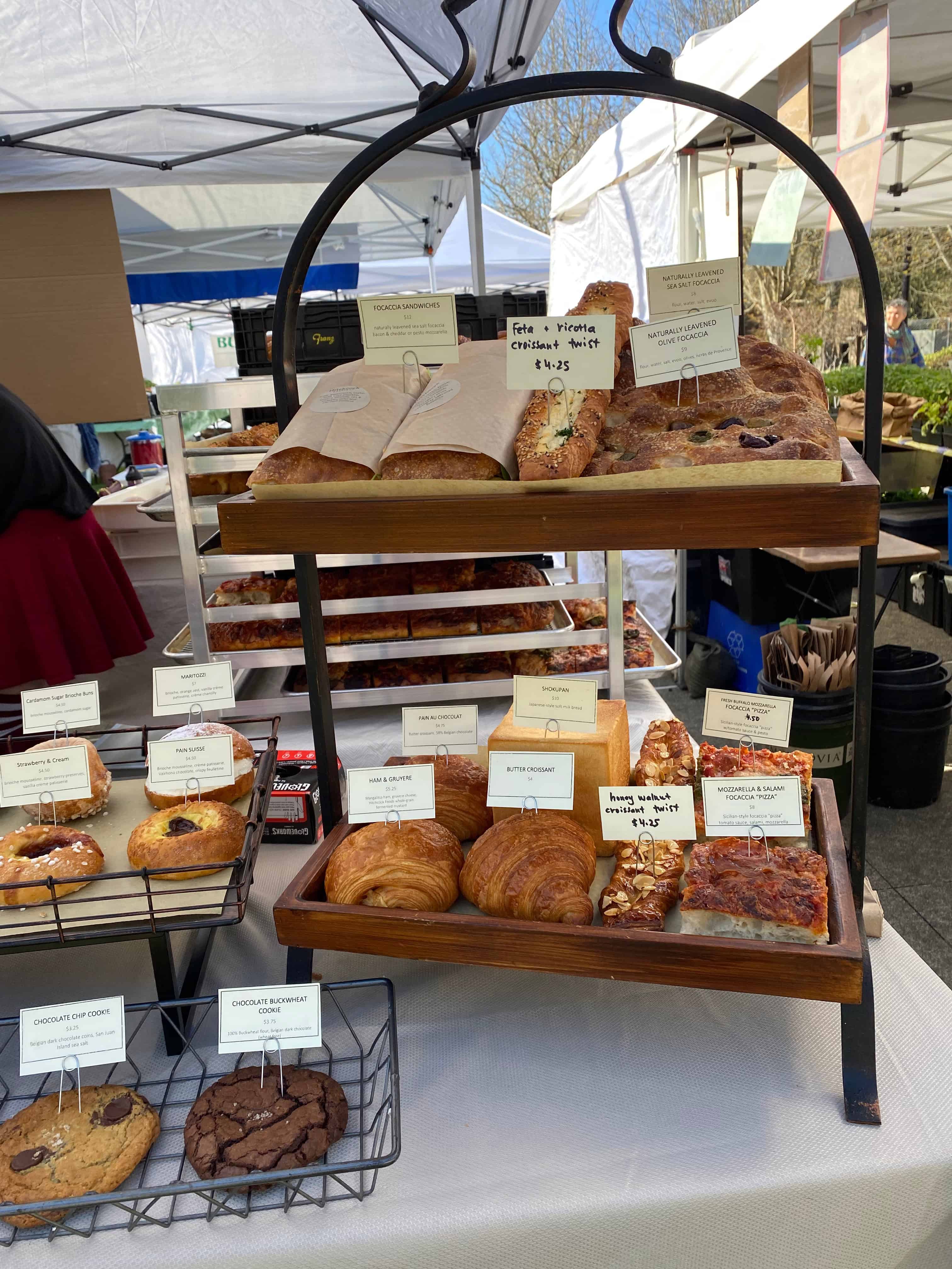 farmer's market bakeshop set-up with baked goods and prices