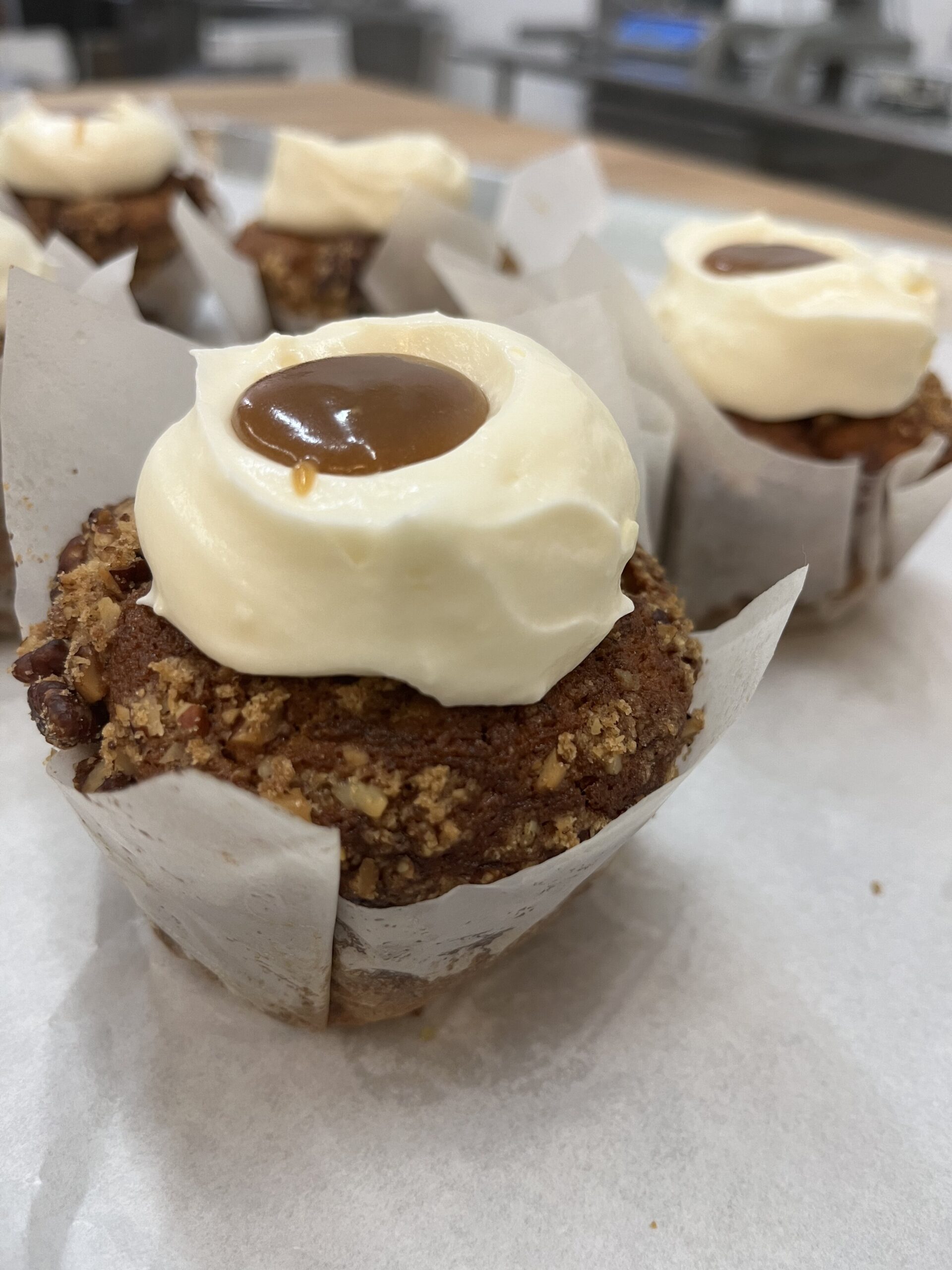 Cupcakes with parchment liner, cream cheese icing and a caramel center