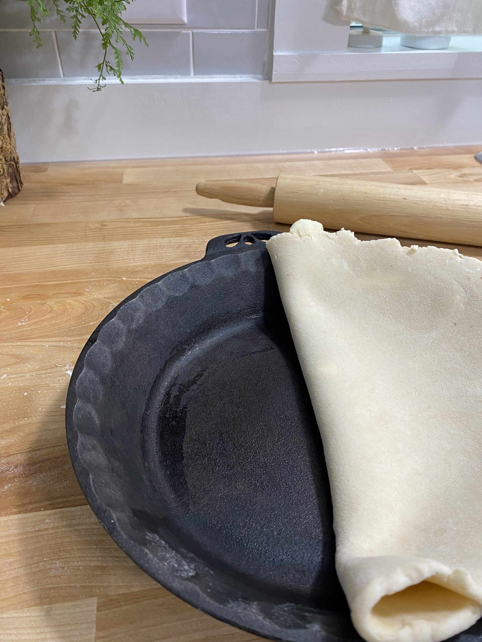 pie dough being laid over pie pan