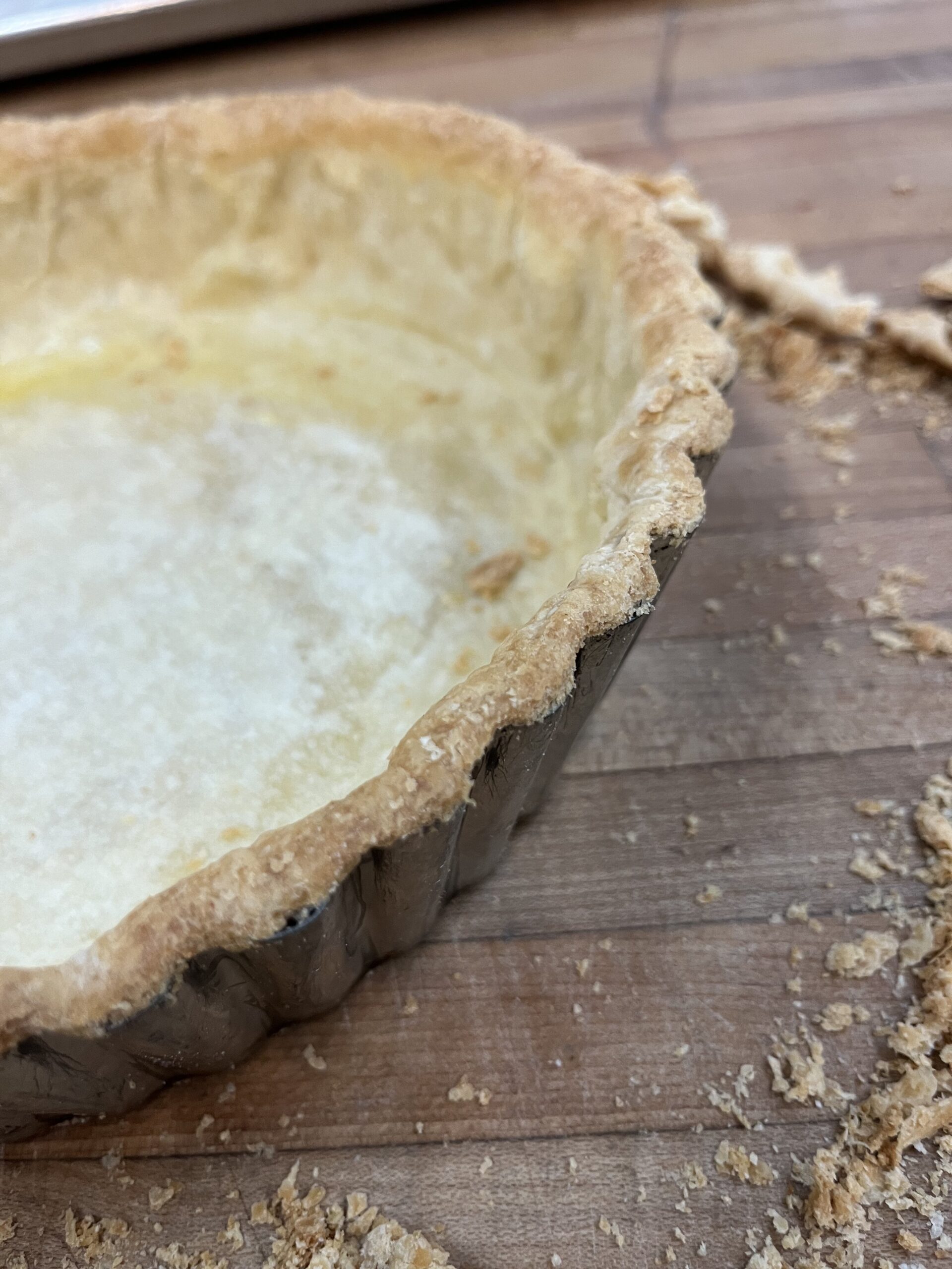 Edge of par-baked pie dough in a deep dish tart pan