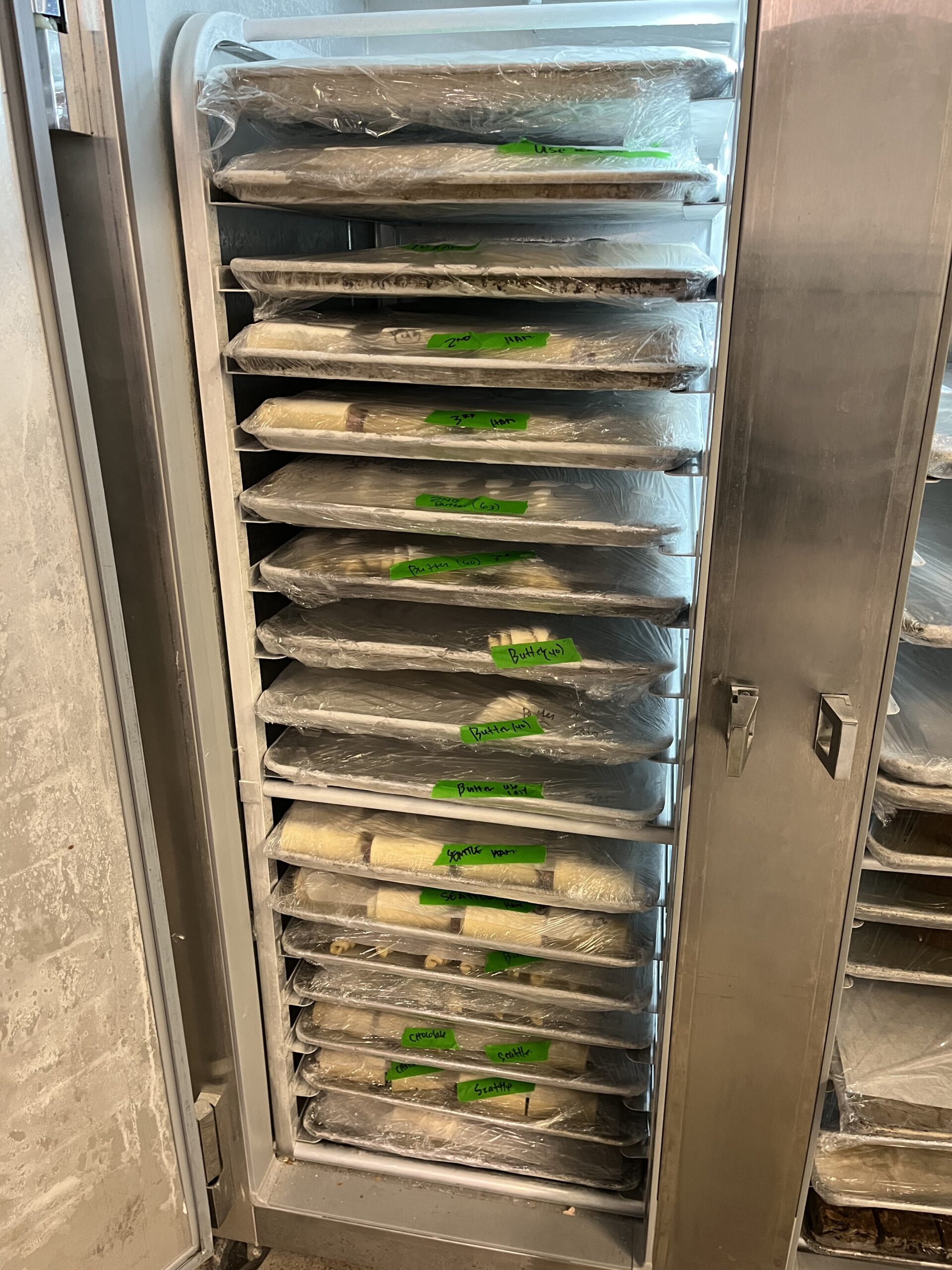 freezer filled with trays of shaped, unbaked croissants
