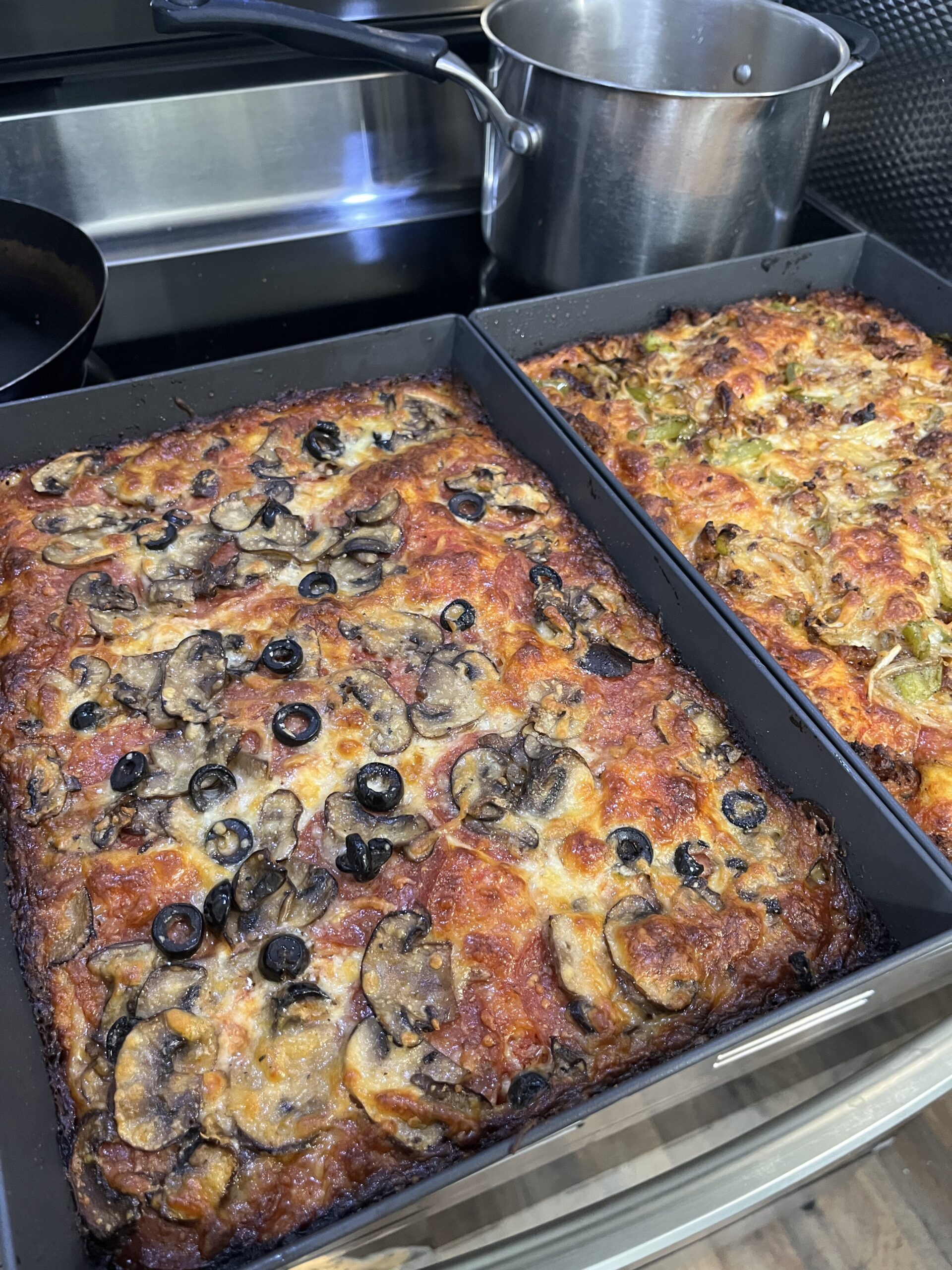 Two pan pizzas in Detroit pizza pans.