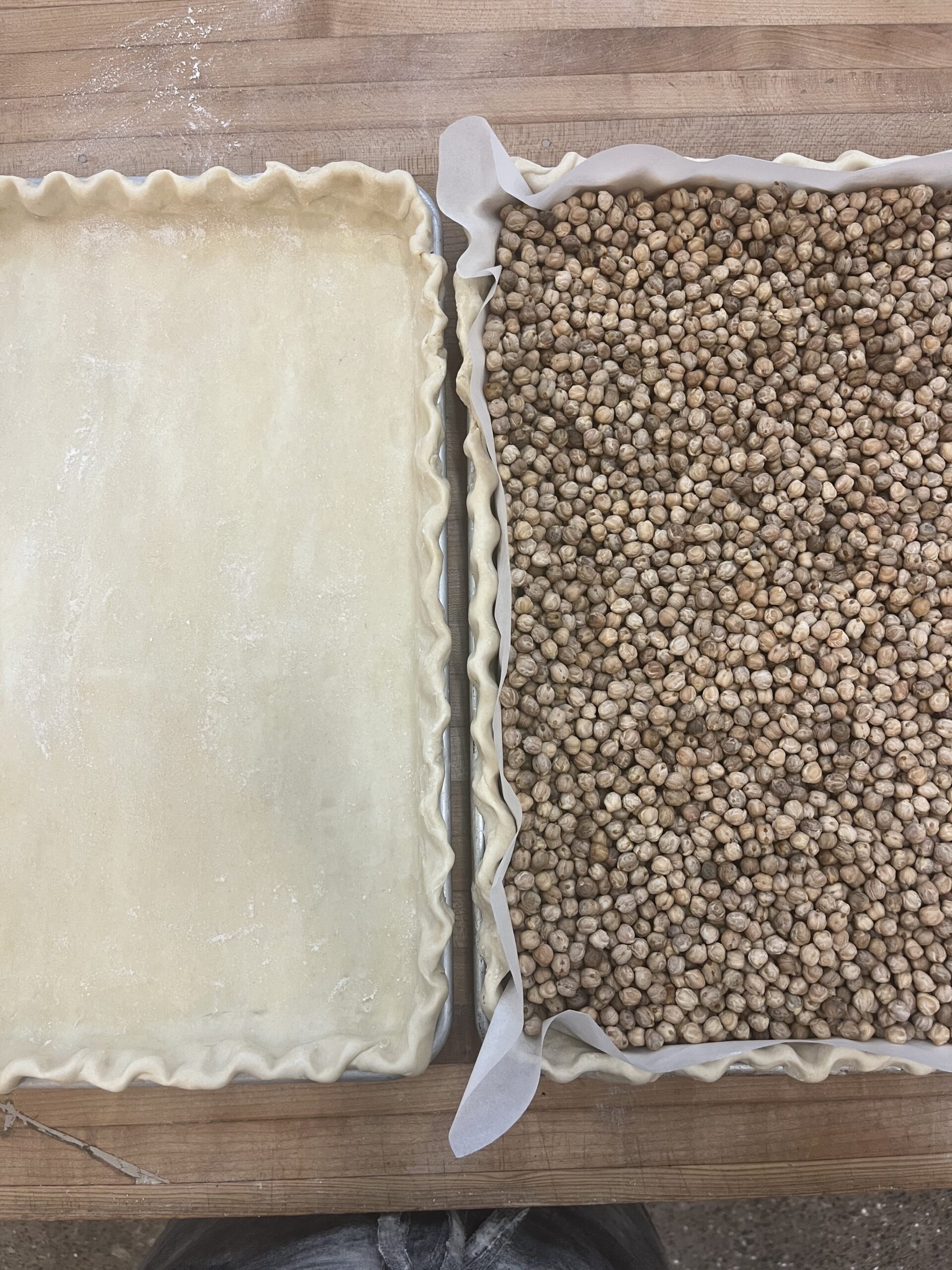 two unbaked rectangular pie shells, one with weights for parbaking