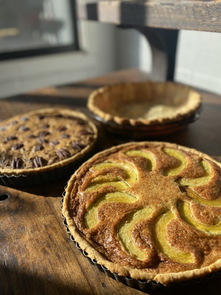 squash pie, pecan pie and empty par-baked crust on table