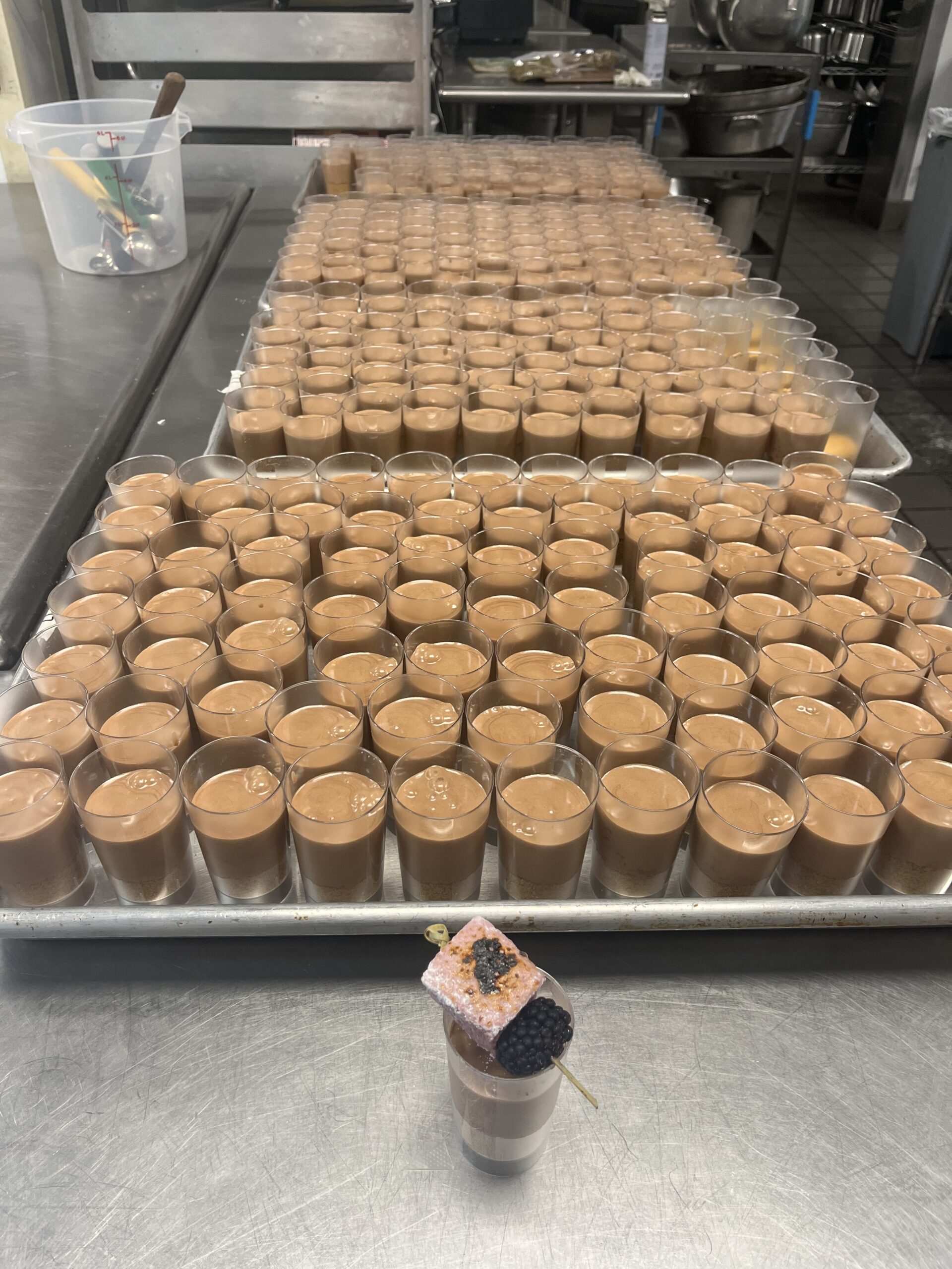 Hundreds of mousse cups on sheet trays.